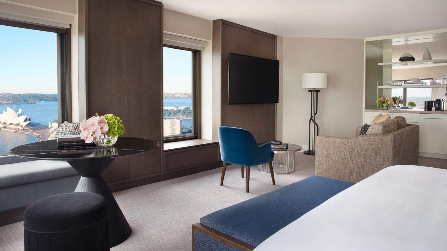 Four Seasons Hotel Sydney Esterno foto The photo showcases a modern hotel room with a sleek and contemporary design. It features a large window that offers a view of the outside. The room includes:

- A comfortable seating area with a blue chair and a light-colored sofa.
- A round black t